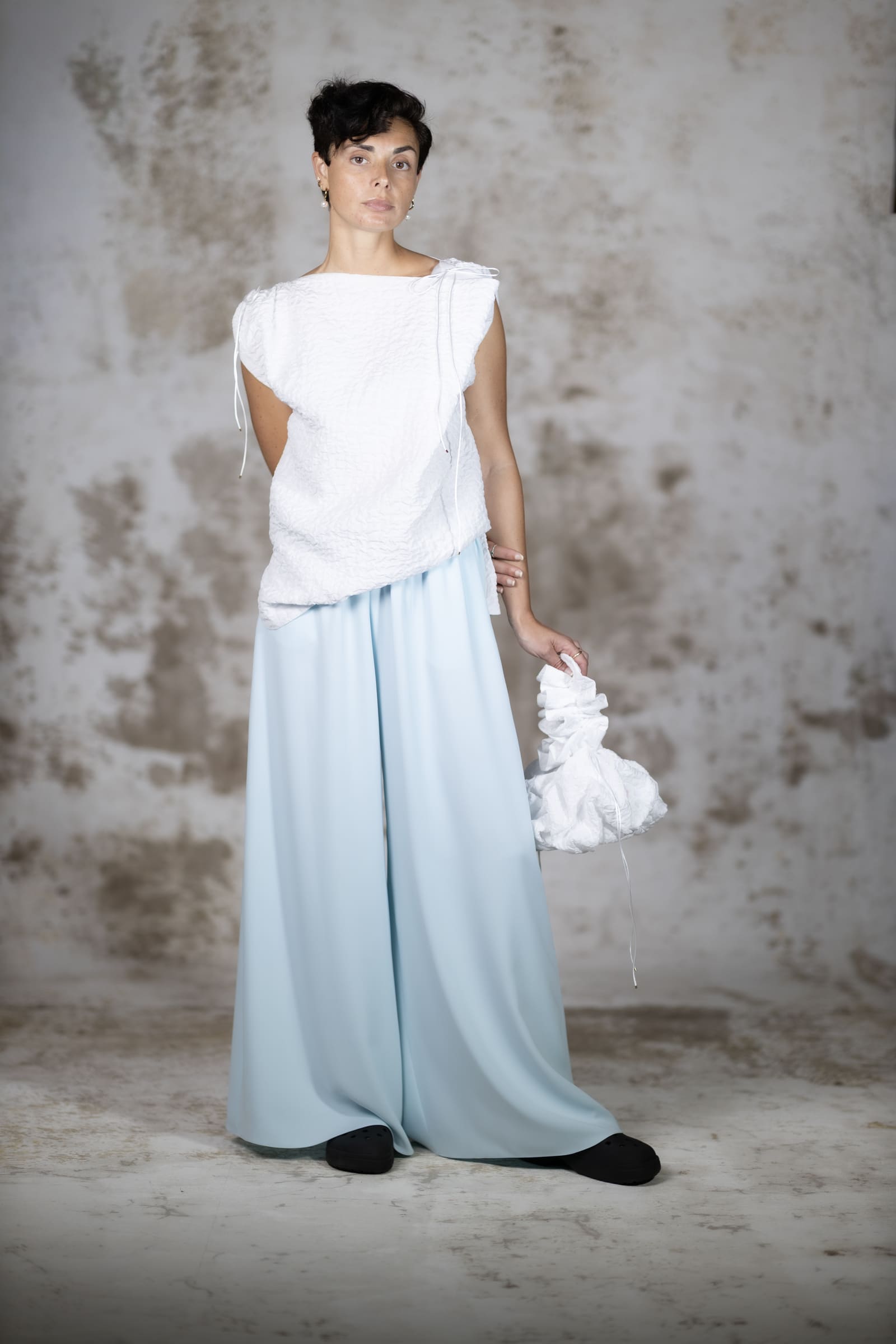 Full-body shot of a model wearing the Escuma blouse and the Blue Pedra Trousers, a clean minimalist top crafted in premium rich jacquard fabric with a structured fit - Anabel Santos