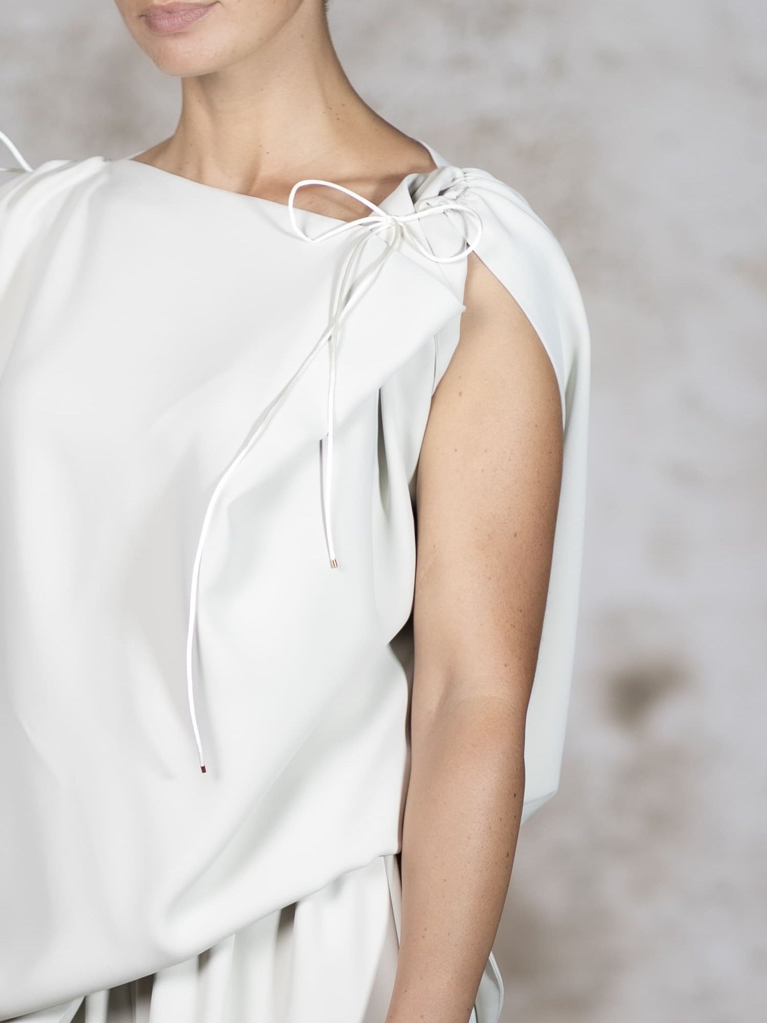 Close-up shot of the Pedra blouse, highlighting the premium crepe texture, flawless stitching, and handcrafted delicate rat-tail ties - Anabel Santos