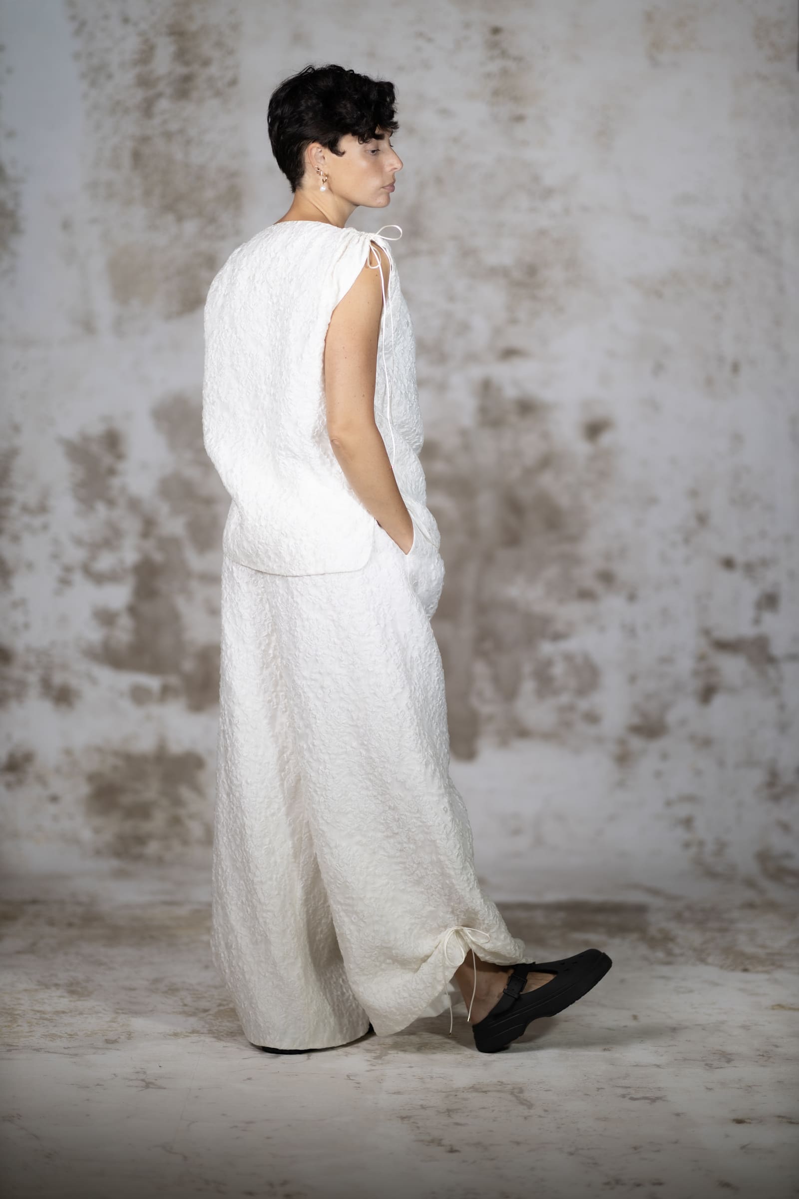 Full-body back view of the Raiola blouse, showcasing the exquisite luminous reflection and brilliant texture of the premium silk jacquard - Anabel Santos