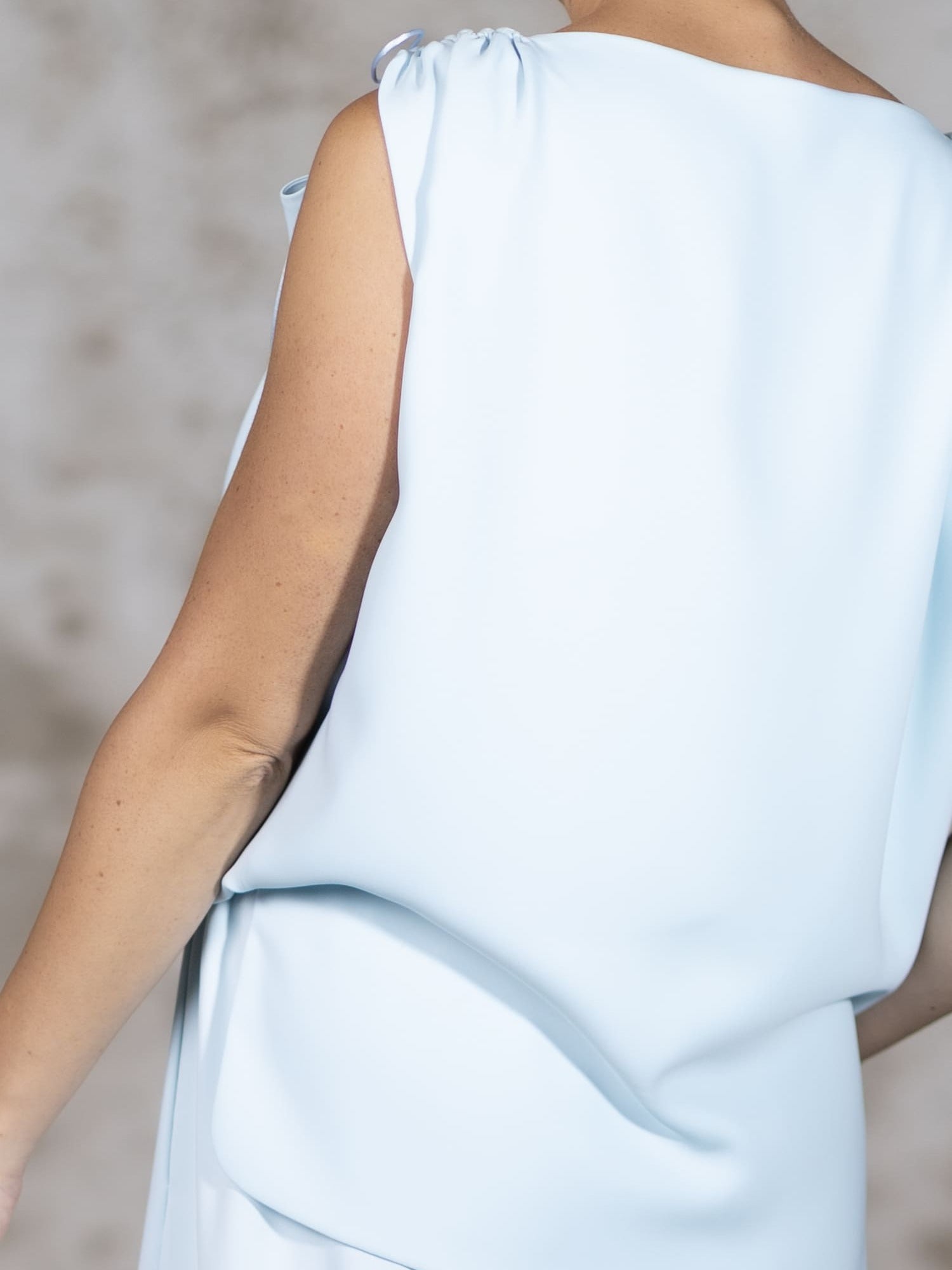 Close-up shot of the Blue Pedra blouse, highlighting the premium light blue crepe texture, flawless stitching, and handcrafted delicate rat-tail ties - Anabel Santos
